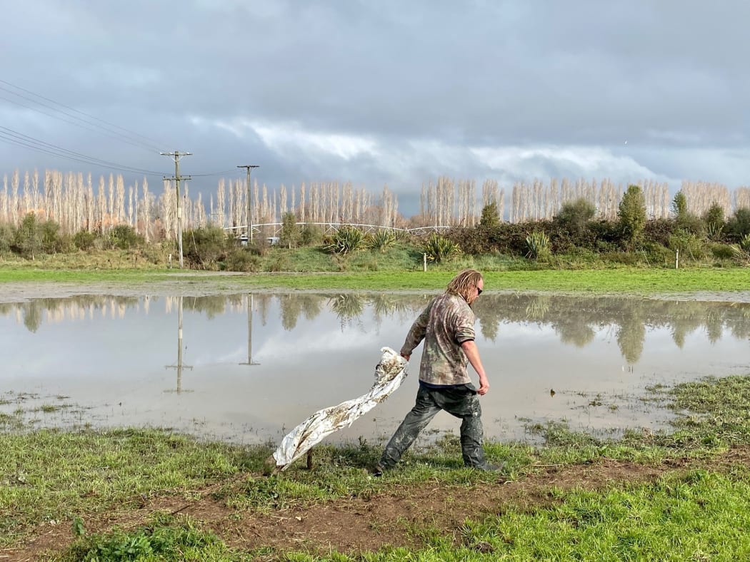 Henry Rooney cleans plastic from silage off his farm.