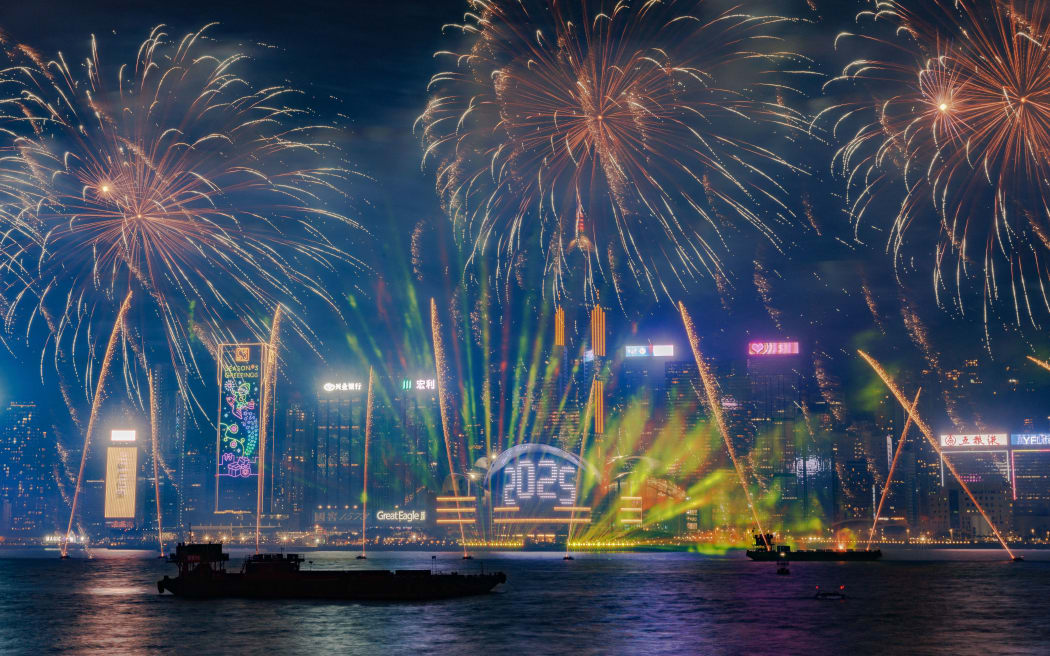 This photograph shows fireworks over the Victoria Harbour to celebrate the New Year in Hong Kong on January 1, 2025. (Photo by MAY JAMES / AFP)
