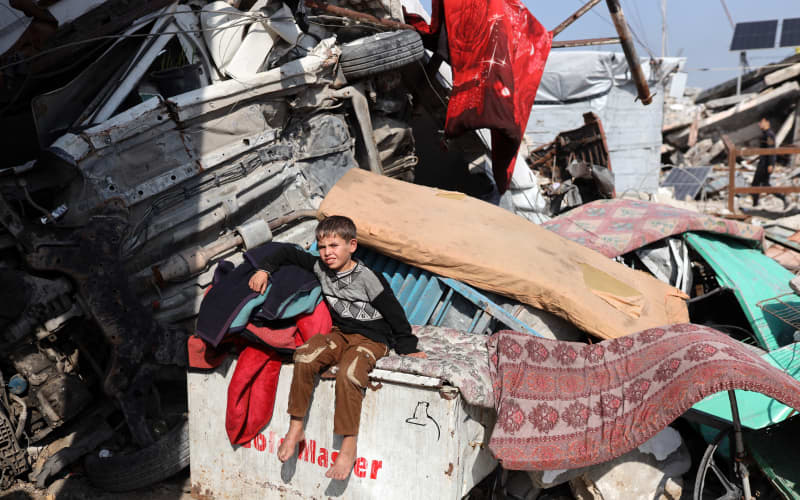 A displaced Palestinian child sits outside his family’s tent in the Jabalia refugee camp in the north of the Gaza Strip on January 6, 2026.
