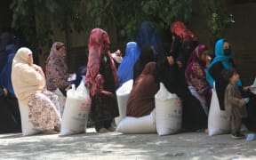 Afghan people receive China-donated food aid in Kabul, Afghanistan, 17 August, 2022.