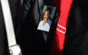 People hold images of Hillsborough disaster victims as they queue to enter the inquest into the disaster.