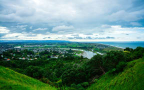 Panoramic aerial view over town of Whakatane. The heart of the Eastern Bay of Plenty, New Zealand, it's nested between Whakatane River and bush-clad cliffs. Breathtaking New Zealand Landscape. Kohi Point Lookout, Whakatane, New Zealand.
