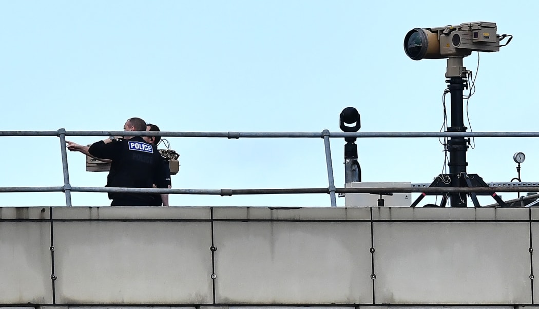 Police officers stand near equipment on the rooftop of a building at London Gatwick Airport, south of London.
