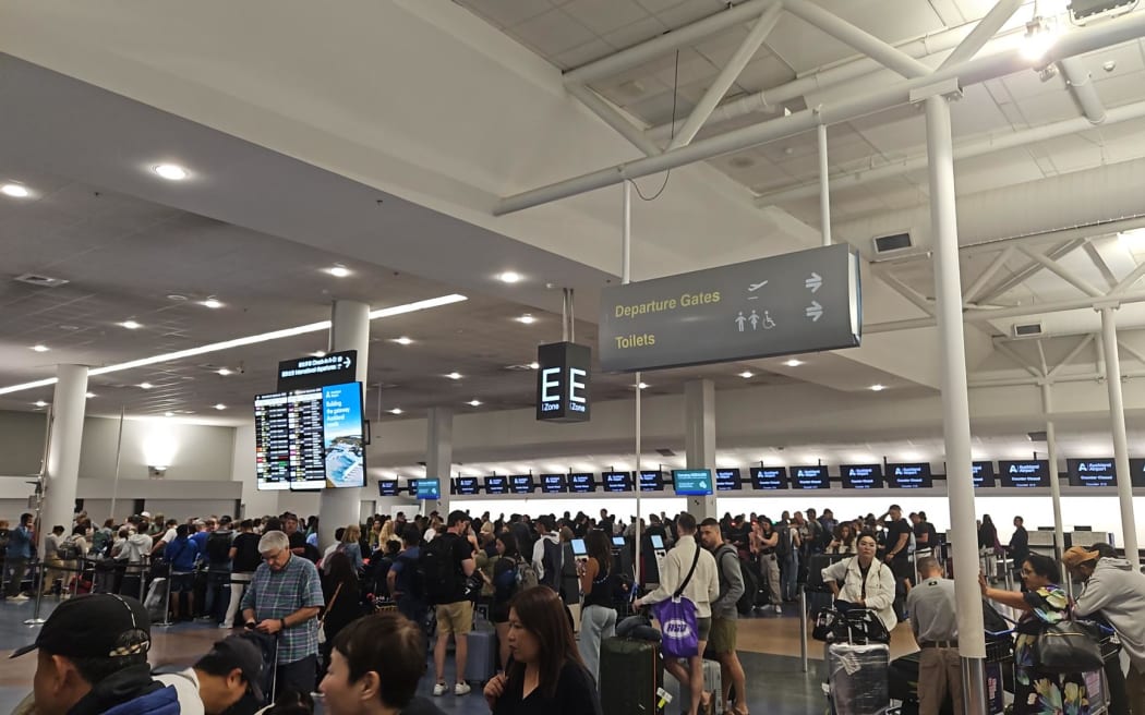 Passengers queue at Auckland International Airport after their flight to Santiago, Chile was cancelled. The plane they were meant to fly on experienced a "technical problem" that saw 13 people hospitalised, one with serious injuries.