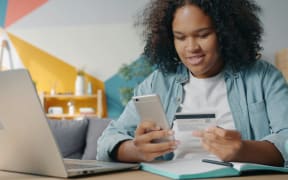 A woman shops online from her phone.