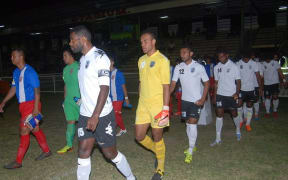 The Fiji and American Samoa football teams head onto the pitch.
