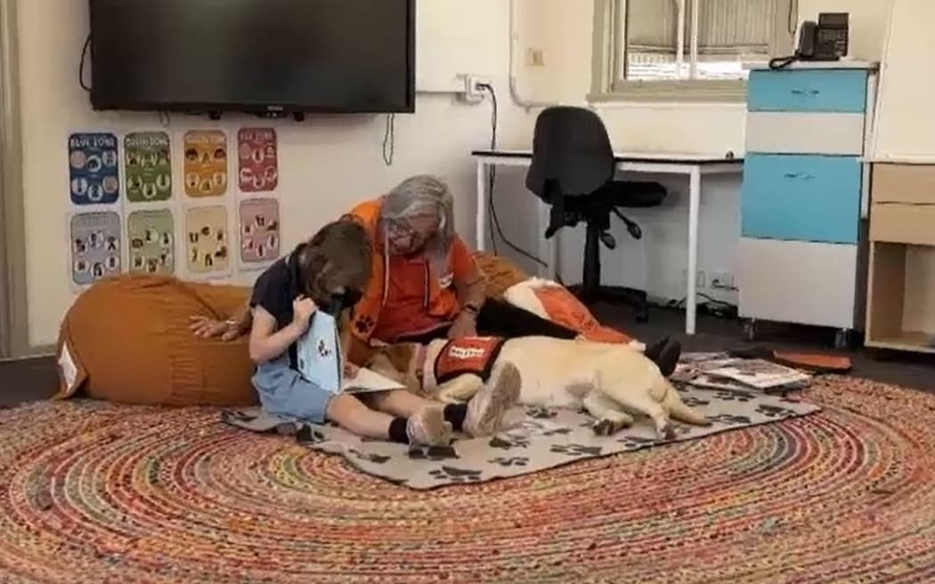 Charlie Pasco reads to Helen Barnett and Piper at Kempsey.