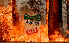 A bushfire burns outside a property near Taree, 350km north of Sydney on November 12, 2019.