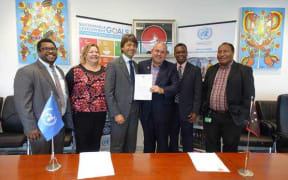 Gianluca Rampolla, United Nations Resident Coordinator in PNG, handed a special land lease by PNG's Minister for Lands & Physical Planning Justin Tkatchenko
