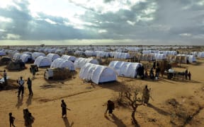 July 31, 2011, shows Somali refugees walking in the new Ifo-extension at the Dadaab refugee camp in Kenya, the largest refugee camp in the world.