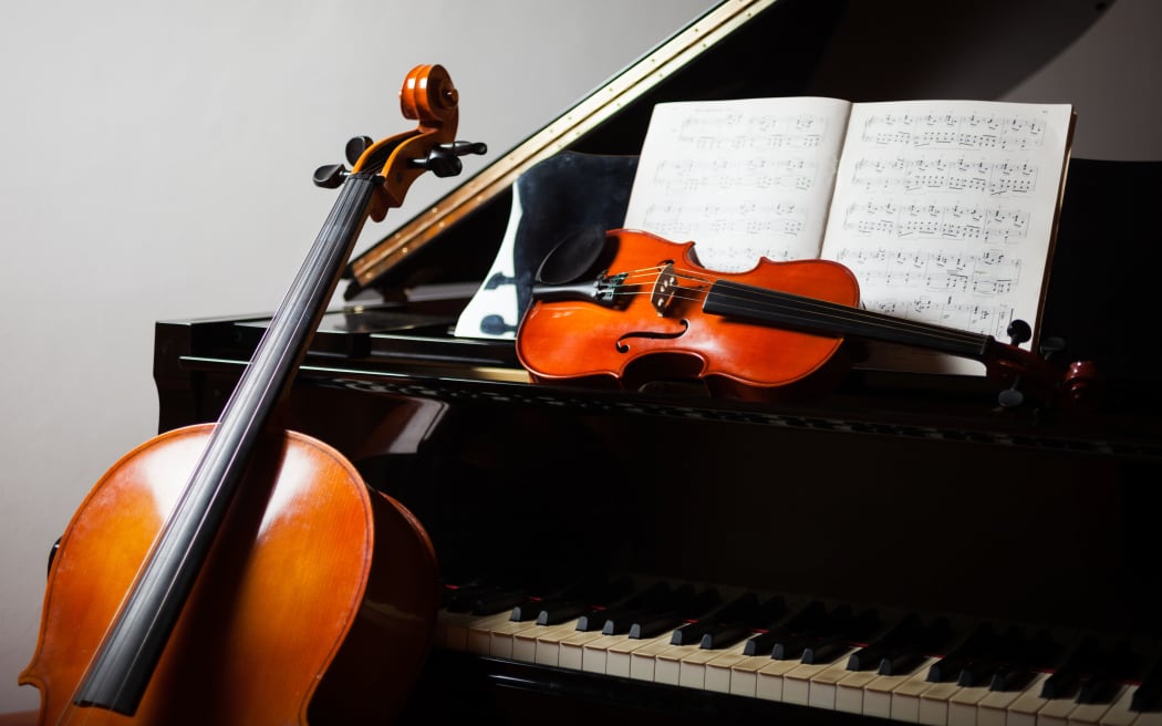Classical music concept: cello, violin, piano and a score