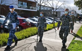 Australian Defence Force personnel escort their staff into the Epping Gardens aged care facility in the Melbourne suburb of Epping on July 28, 2020 as the city battles fresh outbreaks of the COVID-19 coronavirus.