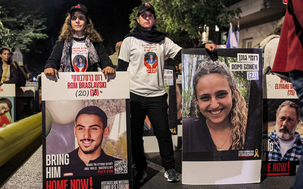 Protesters stand with portraits of Israeli hostages Rom Braslavski (20), Romi Gonen (23), and others during a demonstration by the families of the hostages taken captive in the Gaza Strip by Palestinian militants during the October 7, 2023 attacks, calling for action to release the hostages, outside the Israeli Prime Minister's residence in Azza (Gaza) Street in central Jerusalem on October 24, 2024 amid Israel's ongoing war with Hamas. (Photo by Ahmad GHARABLI / AFP)