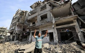 A Palestinian man reacts as he stands amid the destruction in the aftermath of Israeli bombardment in al-Karama district in Gaza City on October 11, 2023. The death toll from five days of ferocious fighting between Hamas and Israel rose sharply overnight as Israel kept up its bombardment of Gaza after recovering the dead from the last communities near the border where Palestinian militants had been holed up. (Photo by Mahmud HAMS / AFP)
