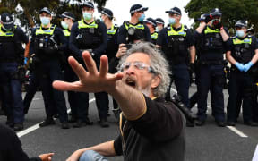 A protester confronts police during an anti-lockdown rally in Melbourne on September 18, 2021.