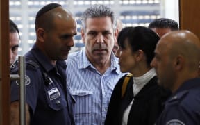 In this file photo taken on July 05, 2018 Gonen Segev (C), a former Israeli cabinet minister indicted on suspicion of spying for Iran, is seen in court in Jerusalem.