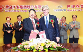 Zijin Mining Group Chairman Chen Jinghe (left) and Barrick Gold Corporation Chairman John L. Thornton (right) signed a strategic cooperation agreement at a ceremony at Zijin’s offices in Xiamen, China on May 26, 2015.