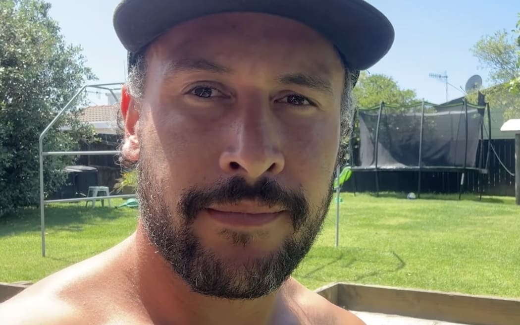 Jordan Watson has a beard and a slight smile and wears a baseball cap.