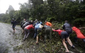 West Coast storm. Tree blocks SH6 south of Hari Hari, around 15 people move the tree from the road.