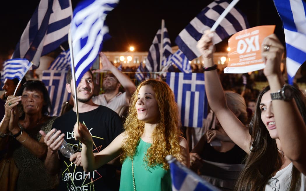 People celebrate in Athens after the first exit-polls of the Greek referendum.