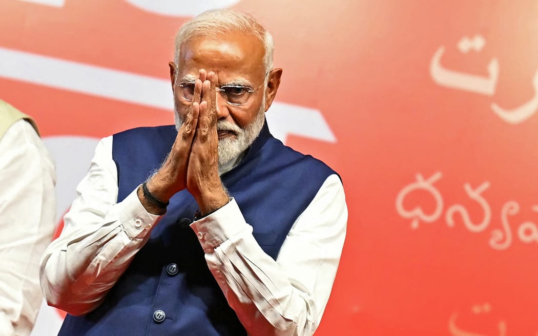 India’s Prime Minister Narendra Modi gestures at the Bharatiya Janata Party (BJP) headquarters to celebrate the party’s win in country's general election, in New Delhi on June 4, 2024. Modi claimed election victory for his party and its allies on June 4, but the opposition said they had "punished" the ruling party to confound predictions and reduce their parliamentary majority. (Photo by Money SHARMA / AFP)
