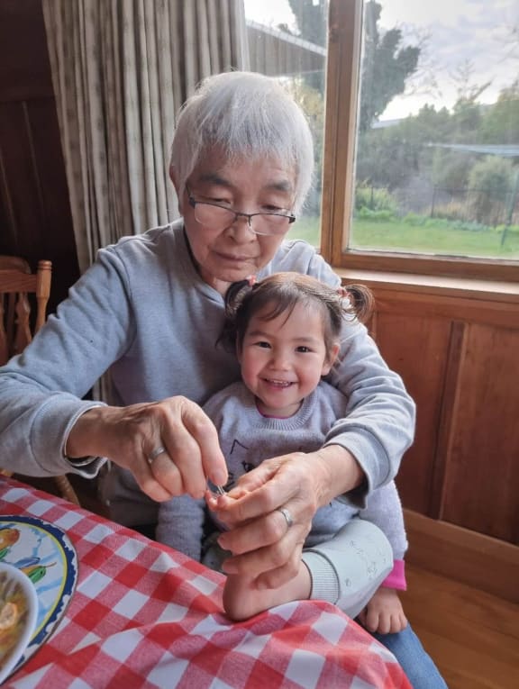 Xiuyun Liu's mum cutting toe nails of the granddaughter