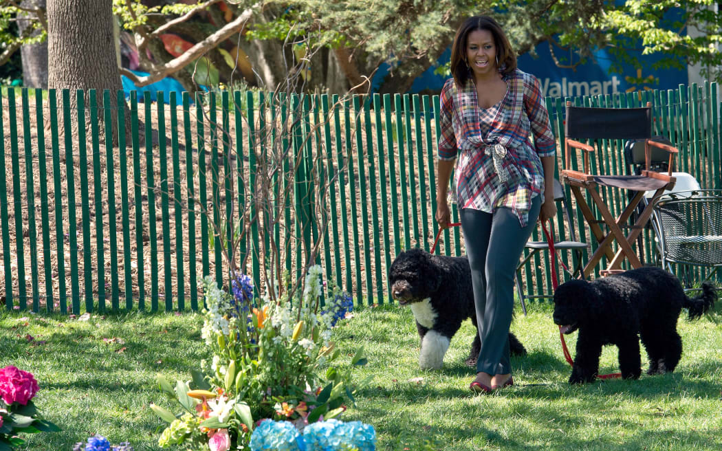 US First Lady Michelle Obama arrives with dogs Bo (L) and Sunny to read a story book during the annual Easter Egg Roll at the White House in Washington on April 21, 2014.