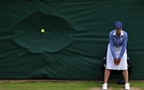 A line judge stands in position as a ball hits the back netting after a serve during the men's doubles semi-final tennis match between Britain's Henry Patten and Finland's Harri Heliövaara, and New Zealand's Michael Venus and Britain's Neal Skupski, on the eleventh day of the 2024 Wimbledon Championships at The All England Lawn Tennis and Croquet Club in Wimbledon, southwest London, on July 11, 2024. (Photo by ANDREJ ISAKOVIC / AFP) / RESTRICTED TO EDITORIAL USE