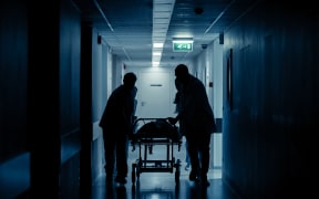 Emergency Department: Silhouettes of Doctors, Nurses and Paramedics Run and Push Gurney / Stretcher with Seriously Injured Patient towards the Operating Room. Modern Hospital with Professional Staff.