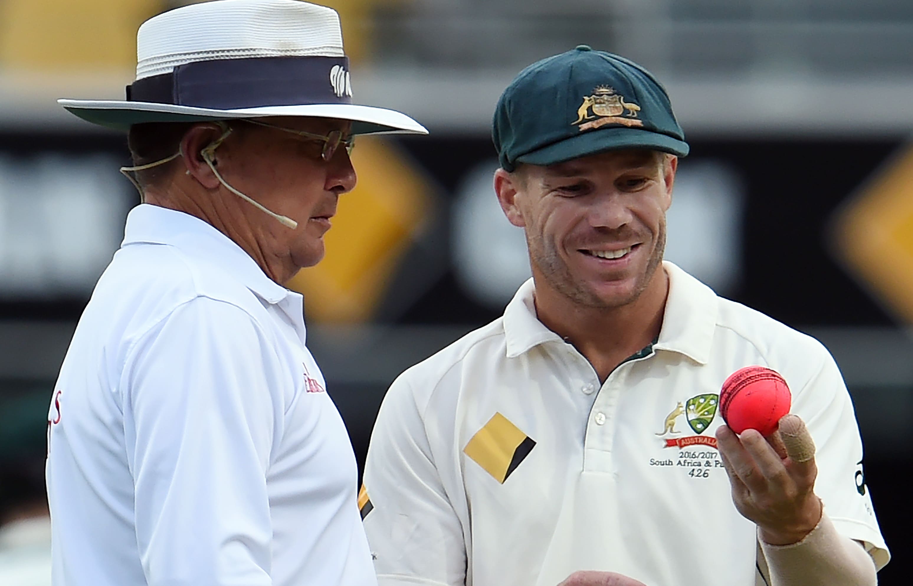 Australia's fielder David Warner (right0 discusses the ball's shape with umpire Ian Gould during a test match between Australia and Pakistan 2016.