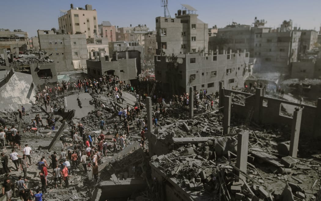10/26/2023, Gaza, Palestine.  After the Israeli airstrike on the 20th day of the conflict in the city of Khan Yunis, the landscape is one of devastation. Many buildings now stand as little more than rubble, while others are heavily damaged. In this dire situation, brave individuals are working tirelessly to rescue survivors and recover the bodies of those who may have tragically perished in the debris of the destroyed houses. (Photo by Mohammad Zanoun / Middle East Images / Middle East Images via AFP)