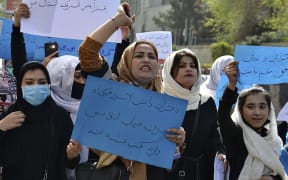 Afghan women and girls take part in a protest in front of the Ministry of Education in Kabul on March 26, 2022, demanding that high schools be reopened for girls. (Photo by Ahmad SAHEL ARMAN / AFP)
