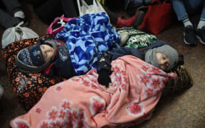 Children are sleeping on the floor at Lviv central train station in Western Ukraine on February 26, 2022.
