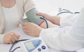 Doctor measures blood pressure of patient.