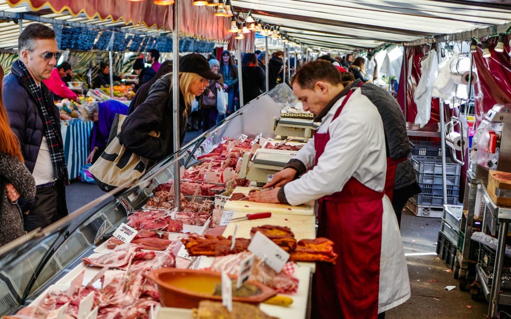 Residents shop for meat products at the President Wilson market on March 14, 2018 in Paris.  / AFP PHOTO / Ludovic MARIN