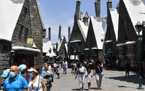 Guests walk through The Wizarding World of Harry Potter at the Universal Studios Hollywood theme park following the state's full reopening on June 15, 2021 in Universal City near Los Angeles, California. California will let fully vaccinated workers go maskless after June 17, Governor Gavin Newsom said Monday. (Photo by Patrick T. FALLON / AFP)