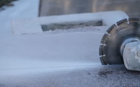 Machine cutting through an engineered stone benchtop.