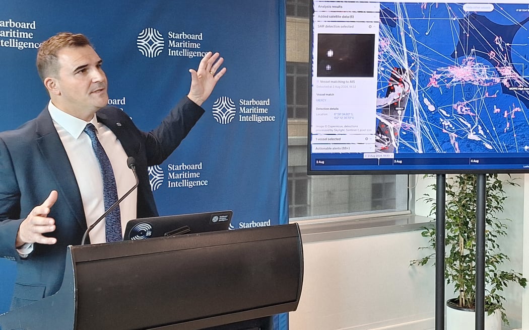 Starboard’s chief revenue officer Mat Brown shows off to government ministers on Thursday at the company’s new Wellington headquarters with a copy of real-time monitoring of fishing vessels in the northwest Pacific.