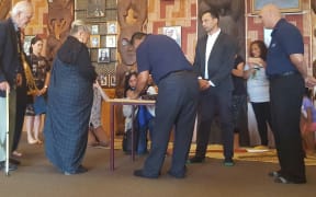 Joe Hawke, left, signs for Ngāti Whātua while Ngati Paoa lead negotiator, Hauauru Rawiri signs for Ngāti Paoa followed by other kaumatua and kuia.