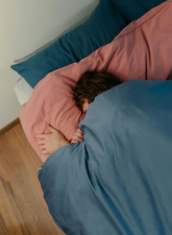 A person snuggles deeply into their pillow.