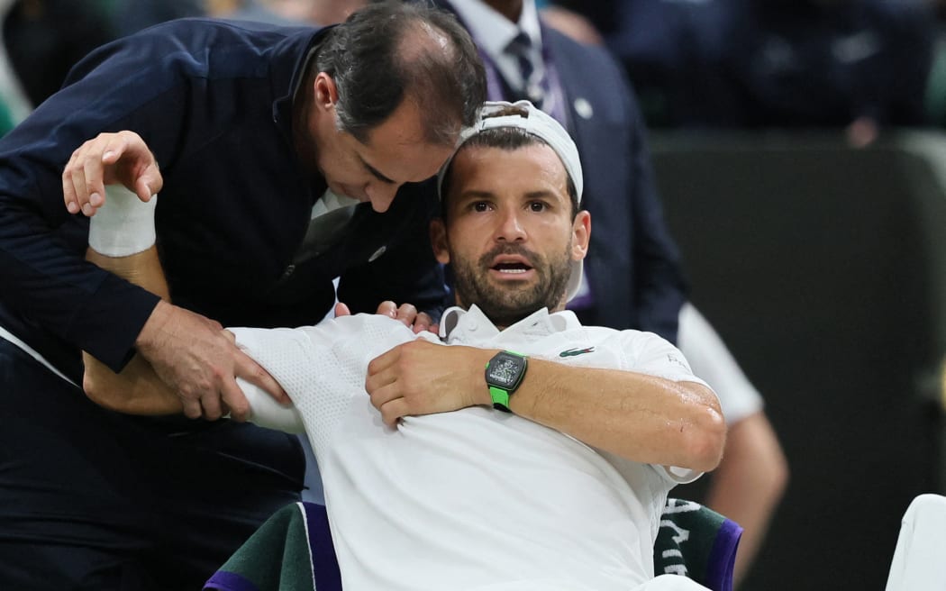Grigor Dimitrov gets attention for a pectoral muscle injury, forcing his withdrawal from his fourth-round men's singles match against Jannik Sinner at Wimbledon, 7 July, 2025. (Photo by Daisuke Urakami / The Yomiuri Shimbun via AFP)