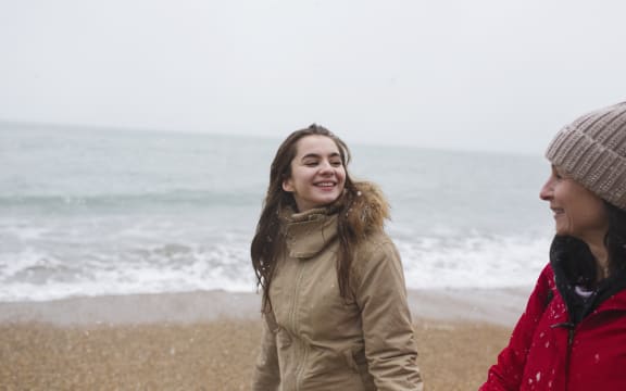 Mother and daughter in warm clothing walking on winter ocean beach. (Photo by CAIA IMAGE/SCIENCE PHOTO LIBRARY / NEW / Science Photo Library via AFP)