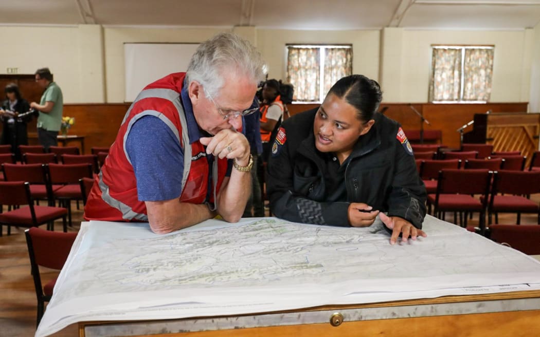 FENZ staff consult a map in the Waipara Memorial Hall following the Waikari Valley fire.