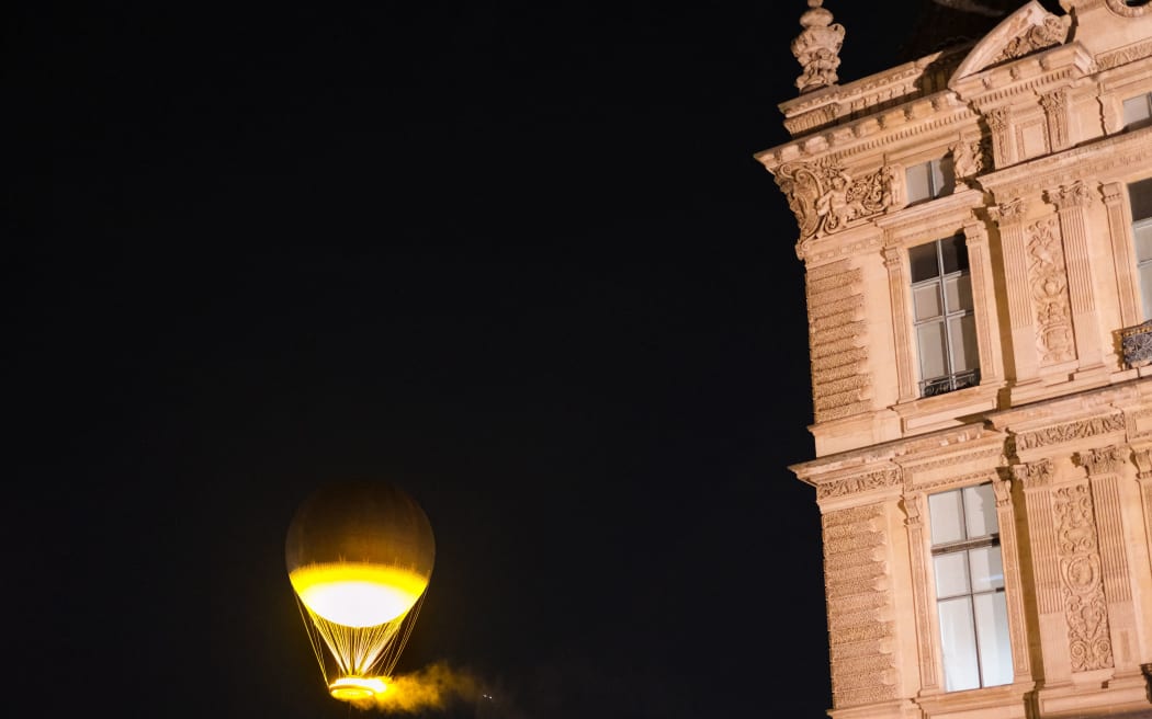 The Paris Olympic and Paralympic Games flame balloon is flying close to the Louvre Museum. (Photo by Vincent Koebel/NurPhoto) (Photo by Vincent Koebel / NurPhoto / NurPhoto via AFP)