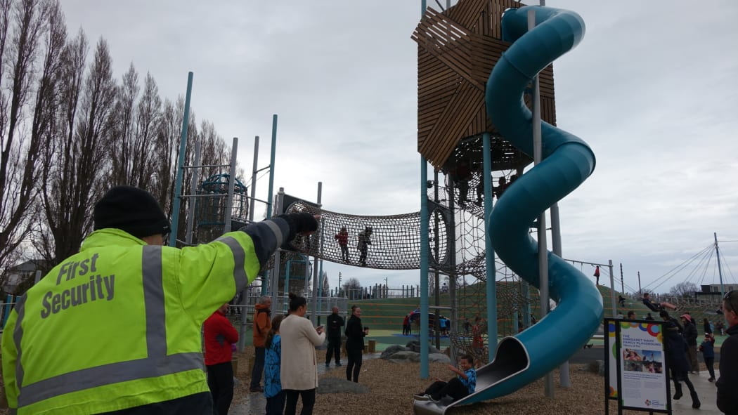 A security guard watches over children at Margaret Mahy Playground.