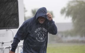 West Coast storm. A man struggles against wind and rain in Hari Hari.
