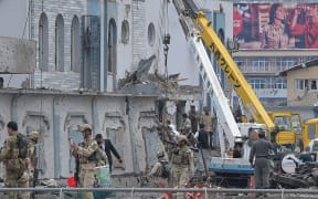 Afghan security personnel inspect the site of the car bomb attack.