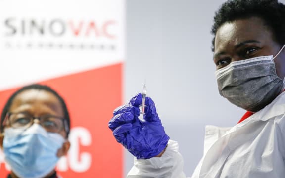 A healthcare worker holds up a SINOVAC Covid-19 vaccine before administering it on a minor during the Numolux/SINOVAC Peadiatric Covid-19 Vaccine Clinical Trial at the Sefako Makgatho Health Sciences University in Pretoria, on September 10, 2021. )