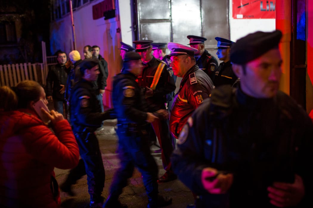 Emergency service and police forces gather near a club in Bucharest.