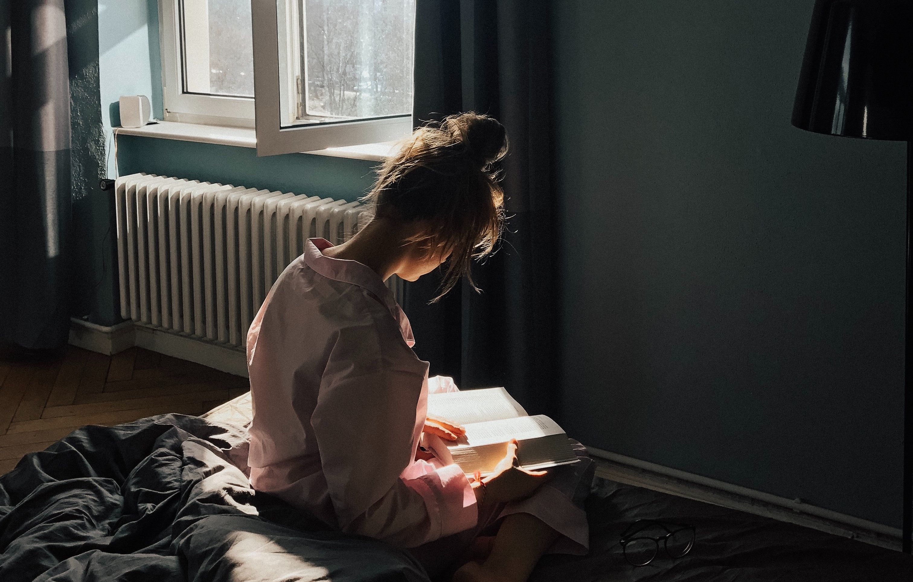 Young woman reading on a bed